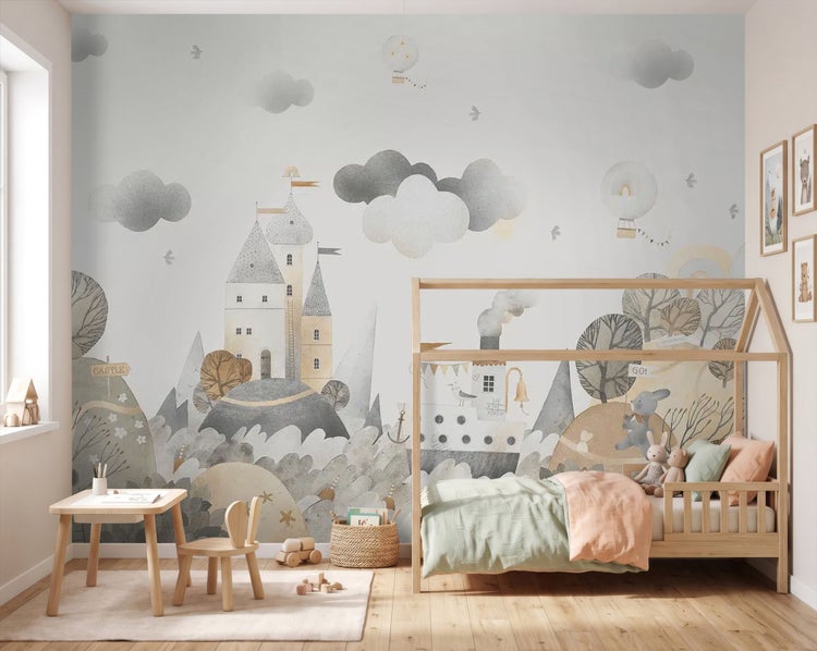 Helles, organisiertes Kinderzimmer mit Vliesfototapete einer illustrierten Abenteuer-Landschaft neben einem Hausbett aus Holz.
