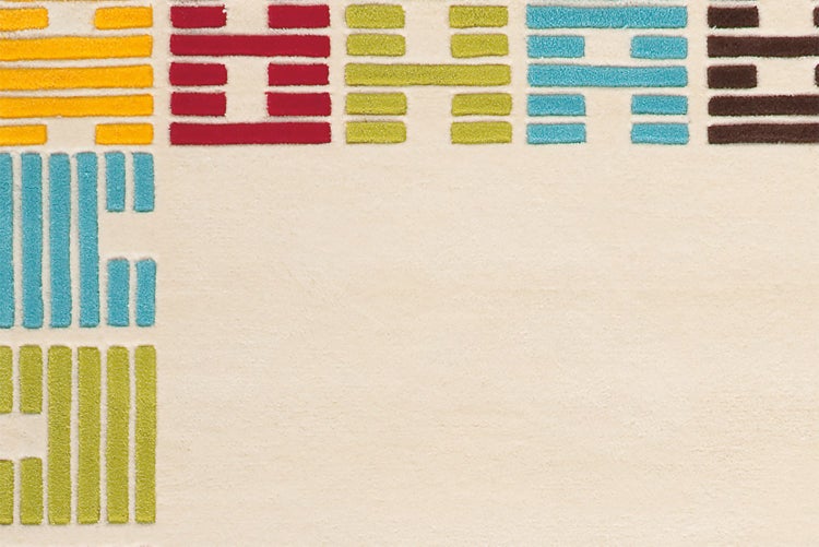 Nahaufnahme eines cremefarbenen Teppichs mit buntem geometrischem Blockmuster.