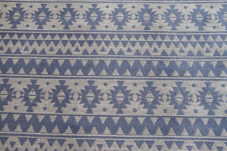 Flachgewebe-Teppich mit blau-beigem geometrischem Ethno-Muster.