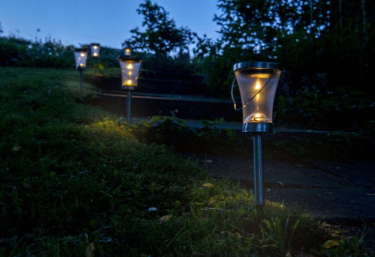 Reihe von Solarleuchten entlang eines Weges in einem Garten bei Nacht