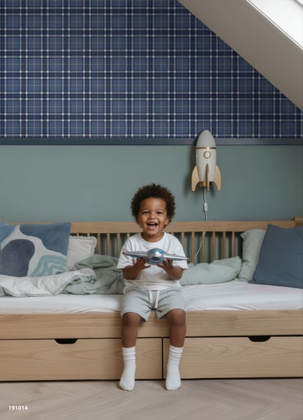 Modernes Kinderzimmer mit blau-weiß karierter Tapete, grüner Wandfarbe, hellem Holzbett mit Schubladen und einer Raketenlampe an der Wand.