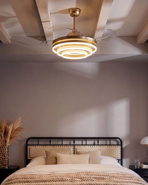 Deckenventilator mit integrierter LED Beleuchtung in modernem Design montiert an der Decke eines Schlafzimmers mit gepolstertem Metallbett.