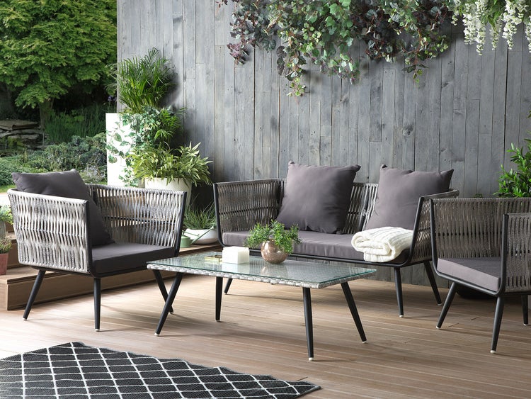Gartenmöbel-Set mit Sofa, Sessel und Tisch auf einer Terrasse