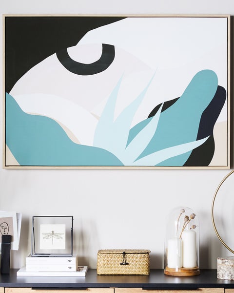 Dekorative Leinwand mit abstrakten Formen über einer Kommode mit Dekorationen