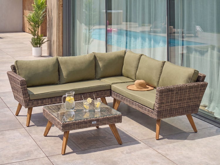 Garten-Lounge-Set aus Polyrattan-Geflecht mit olivgrünen Polstern, L-förmigem Sofa, Couchtisch mit Glasplatte und Holzbeinen auf einer Terrasse.