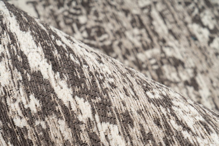 Detailansicht eines gewebten Teppichs mit abstraktem, meliertem Muster.