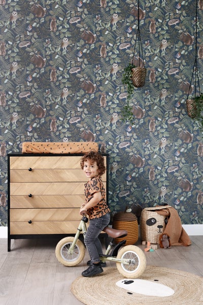 Kinderzimmer mit Kommode, Laufrad und Waldtiertapete
