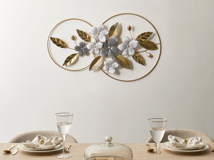 Dekorative Metallwanddekoration mit Blütenmotiven über einem gedeckten Esstisch