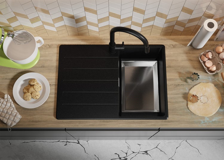 Küchenszene mit Spüle, Armatur und Backutensilien auf einer Arbeitsplatte.