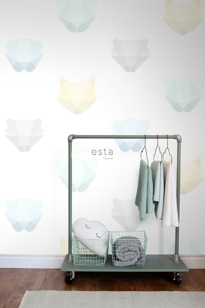 Raum mit einer Garderobe, Textilien und einem Kissen vor einer Tapete mit Tiermotiven