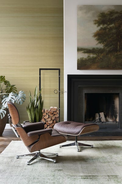 Wohnzimmer mit Sessel, Ottomane, Kamin und Dekoration für eine gemütliche Atmosphäre.