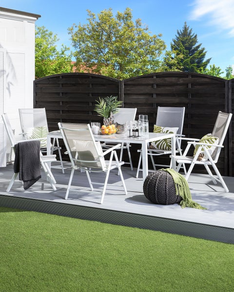 Gartenmöbelset mit Tisch und sechs Stühlen auf einer Terrasse mit Rasenfläche