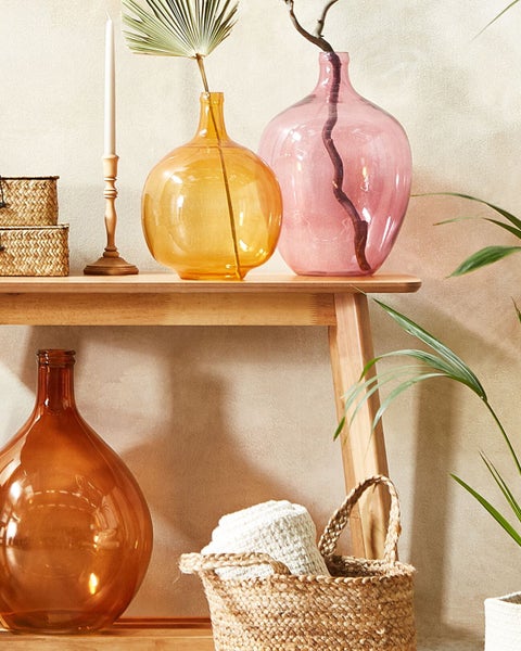 Dekoratives Arrangement mit Vasen und Aufbewahrungskörben auf einem Regal