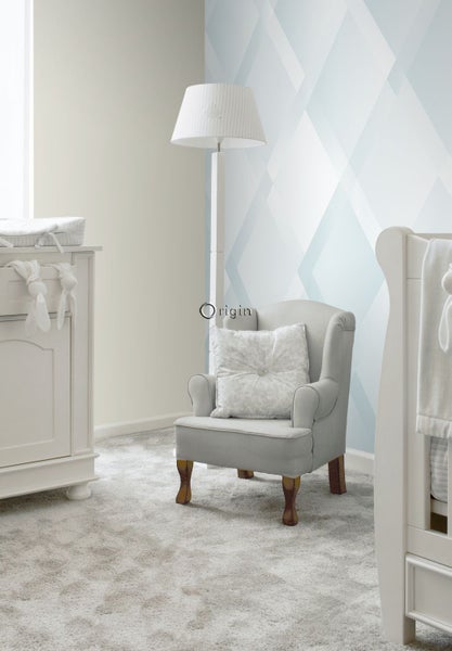 Einrichtung eines hellen Kinderzimmers mit Sessel, Stehlampe und Wickelkommode