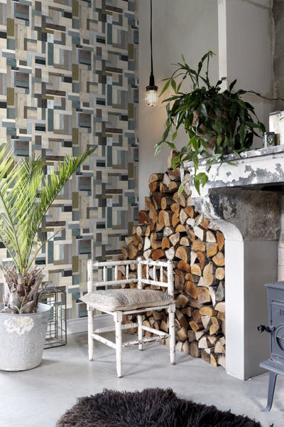 Wohnzimmer mit Holzwandtapete, Kamin, Holzstapel und Zimmerpflanzen