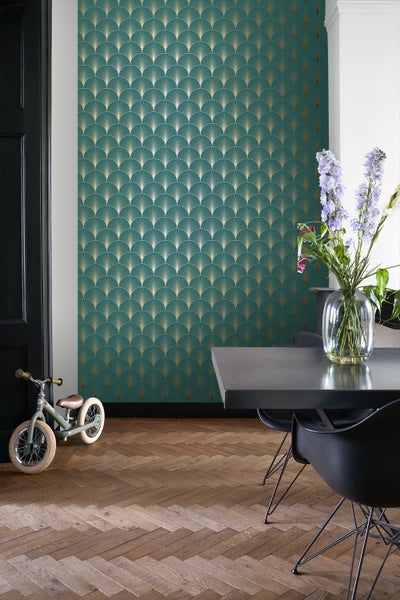 Wohnraum mit goldfarbenem Fächermuster-Tapete, Tisch und Kinderfahrrad