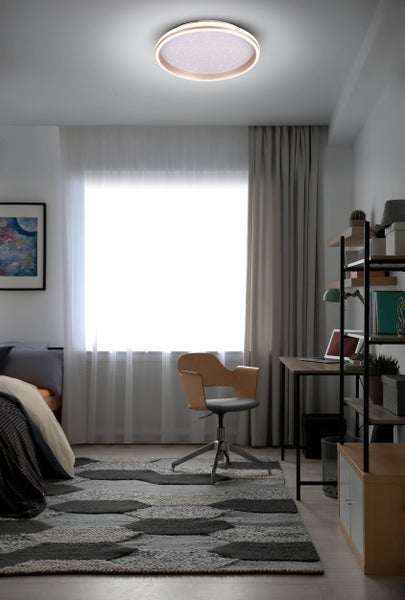 Helles Schlafzimmer mit rundem Deckenlicht, Bett, Schreibtisch und Stuhl