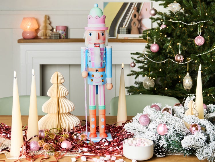 Festliche Tischdekoration mit Nussknacker, Weihnachtsschmuck und Kerzen für Weihnachten