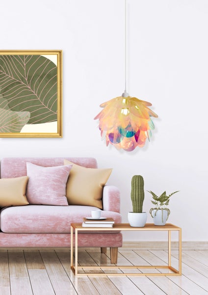 Wohnzimmer mit rosa Sofa, Couchtisch, Zimmerpflanzen, Lampe und gerahmtem Bild