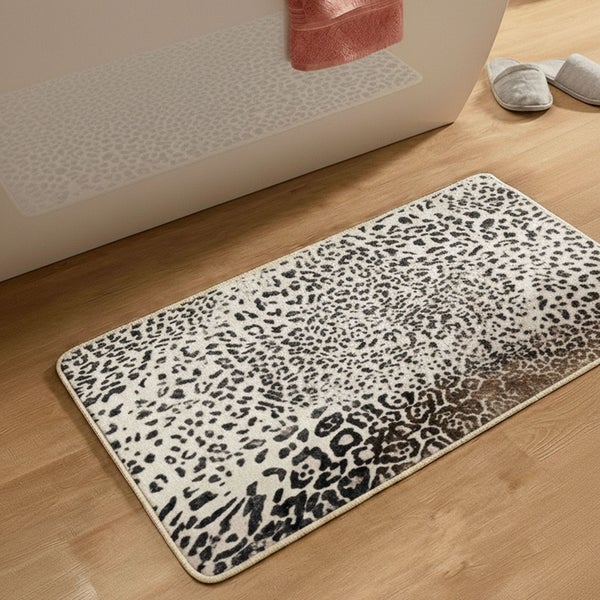 Rechteckige Badematte mit Leopardenmuster auf Holzboden vor einer weißen Badewanne.