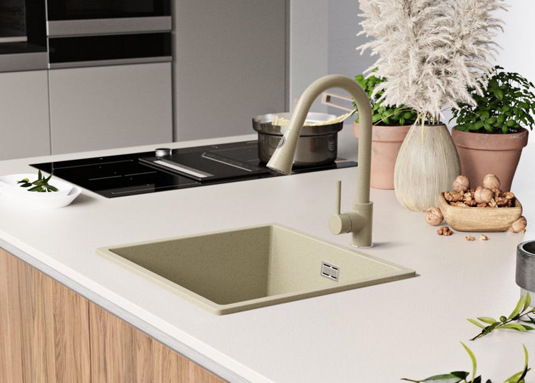 Küchenspüle mit Armatur auf einer Küchentheke mit Kochfeld und Dekoration