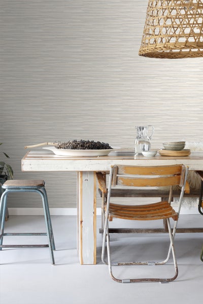 Szene mit Esstisch, Stühlen und horizontal gemusterter Tapete für ein stilvolles Interieur