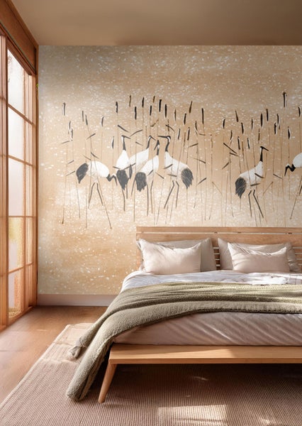 Schlafzimmer mit Wandtapete mit Kranichmotiven, Bett und Teppich für eine ruhige Atmosphäre.