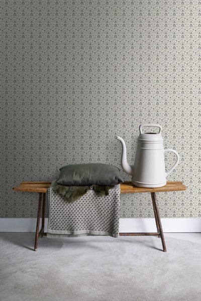 Dekorative Tapete mit Blumenmuster, kombiniert mit Sitzbank, Kissen und Gießkanne.