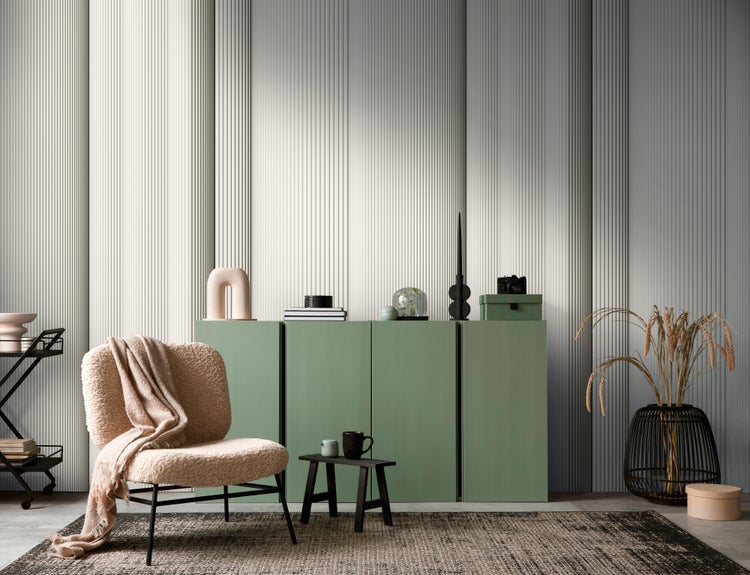 Modernes Wohnzimmer mit grünem Sideboard, beigem Teddy-Sessel und hellgrauen Wandpaneelen mit vertikaler Lamellenstruktur.