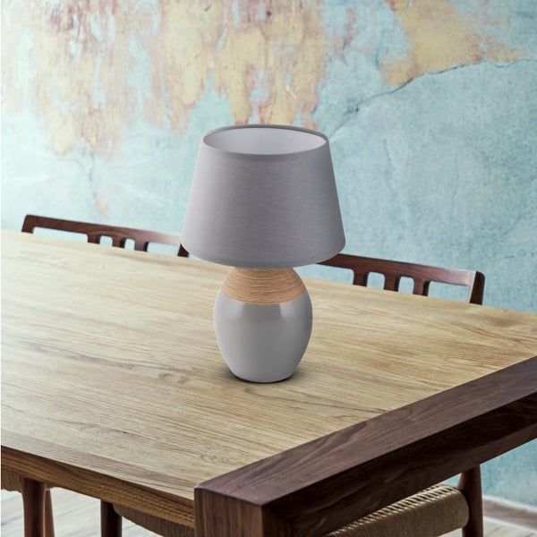 Dekorative Tischleuchte mit Lampenschirm auf Holztisch