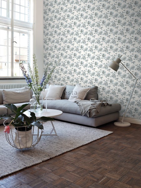 Wohnzimmer mit Sofa, Tisch, Stehlampe und Tapete mit Rosenmuster