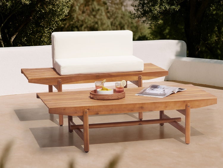 Gartenszene mit Holzbank und Couchtisch mit Getränken und Zeitschrift