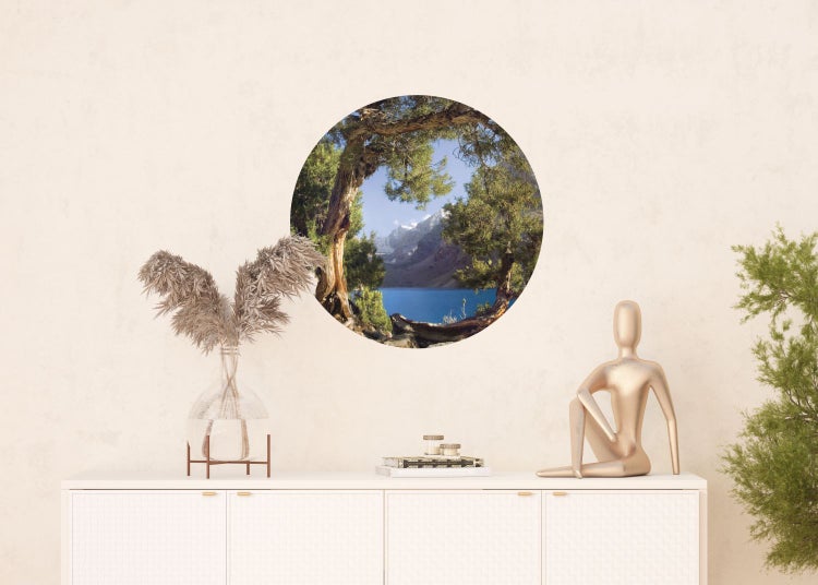 Wandbild mit See- und Bergmotiv in runder Form über einem Schrank