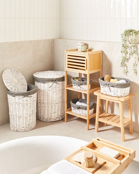 Helle Badezimmerszene mit Wäschesammlern aus Korbgeflecht sowie Regal und Hocker aus Bambus für eine organisierte Aufbewahrung.