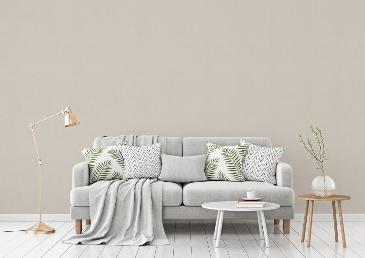 Wohnzimmer mit Sofa, Kissen und Beistelltischen