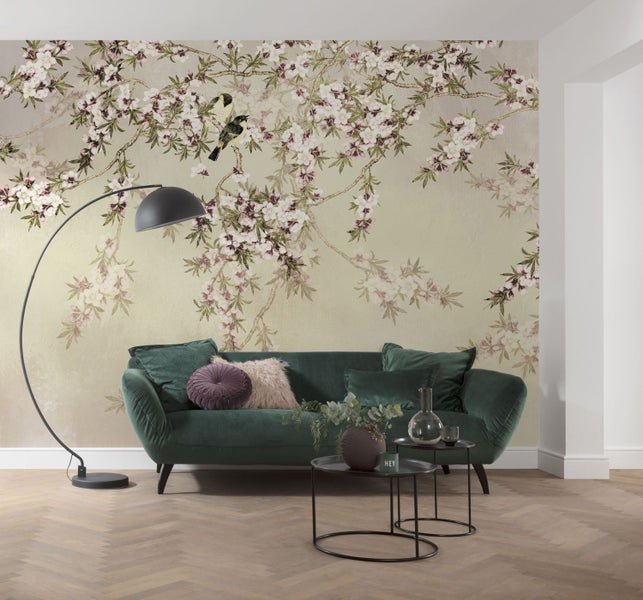 Wohnzimmer mit floraler Tapete, grünem Sofa und Stehlampe