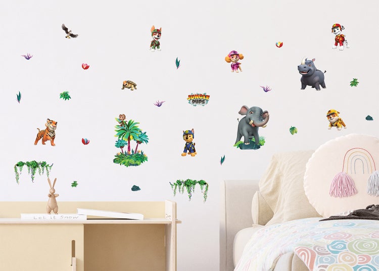 Wandtattoos mit PAW Patrol Jungle Pups Motiven in einem hellen Kinderzimmer über einem Bett und einem Regal.