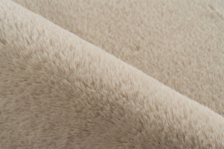 Detailansicht der weichen Textur eines beigen Hochflor-Teppichs aus Kunstfell.