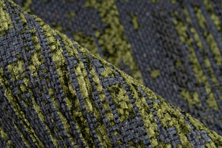 Nahaufnahme eines gewebten Polsterstoffes mit strukturierter grüner und grauer Musterung.