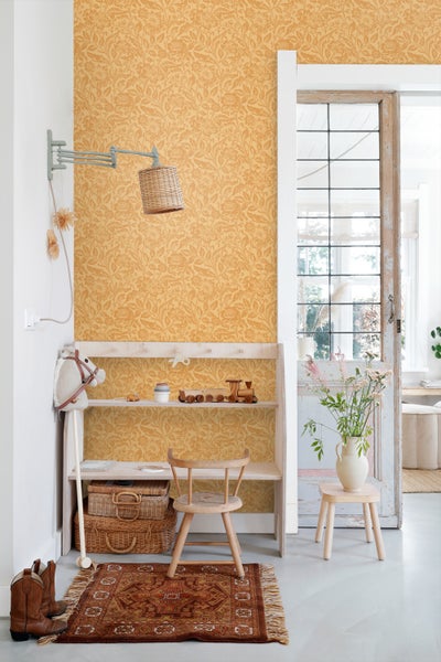 Kinderzimmer mit floral gemusterter Tapete, Regal mit Spielzeug, Holzstuhl und Teppich