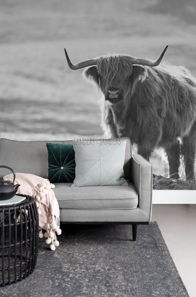 Wohnzimmer mit grauem Sofa, Zierkissen, Beistelltisch, Teppich und Schwarz-Weiss-Wandbild