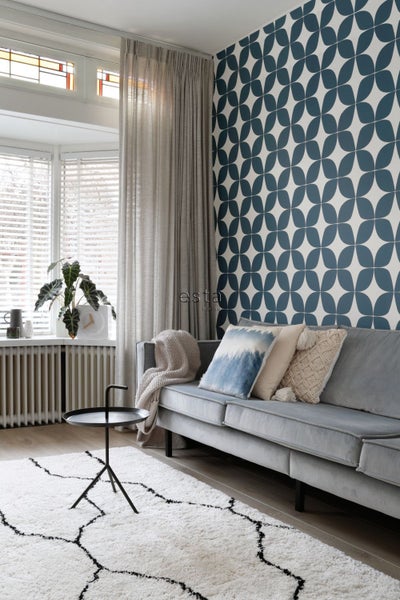 Wohnzimmer mit Sofa, Teppich und gemusterter Tapete