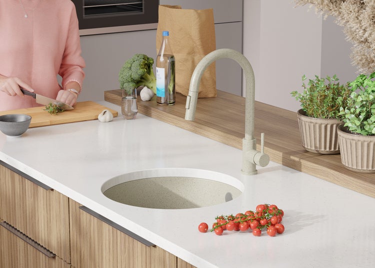 Küchenszene mit Spüle, Armatur und frischen Zutaten