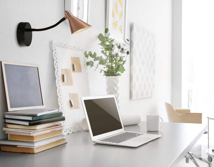 Schreibtisch mit Laptop, Büchern und dekorativen Elementen für einen organisierten Arbeitsbereich