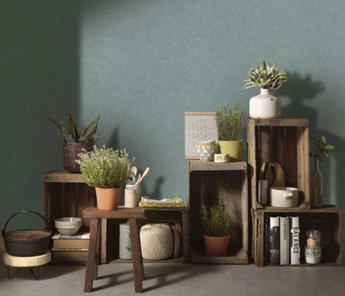 Dekorative Szene mit Uhr, gerahmtem Bild, Vase und Blumen auf einem Tisch vor einer Wand