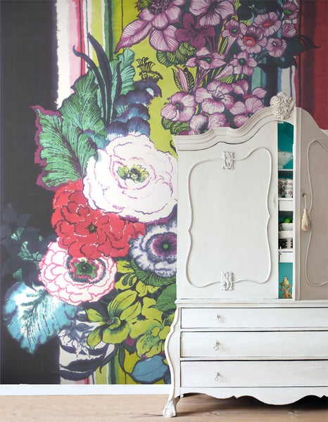 Dekorative florale Tapete mit antikem Schrank im Raum.