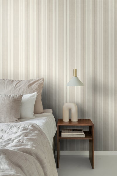 Schlafzimmer mit gestreifter Tapete, Bett und Nachttisch