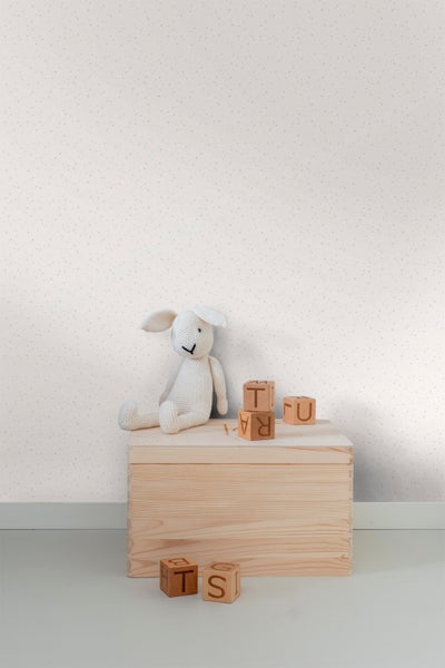 Tapete mit Punktmuster, Holzbox und Spielzeugblöcken im Kinderzimmer
