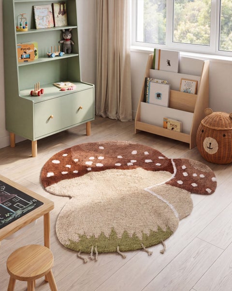 Runder Kinderteppich in Pilzform in einem hell eingerichteten Kinderzimmer mit Holzmöbeln und Spielzeug.