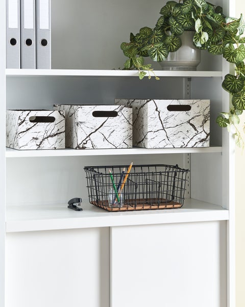 Nahaufnahme eines Teppichs mit Fransen und abstraktem Muster in Dunkelblau und Weiß.